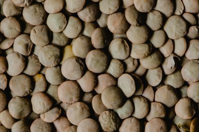 High-resolution close-up image showcasing the texture of dried brown lentils in natural light. Image en gros plan haute résolution mettant en avant la texture des lentilles brunes séchées à la lumière naturelle.