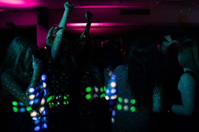 Scène de discothèque énergique avec des gens qui dansent sous des lumières néon colorées. Parfait pour les thèmes de la vie nocturne.