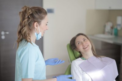 Dentiste souriant en consultation avec une patiente
