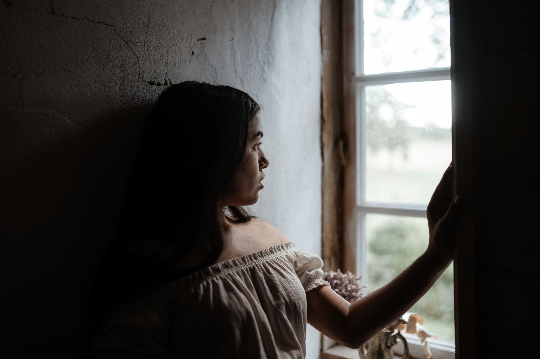 Femme sereine regardant par la fenêtre
