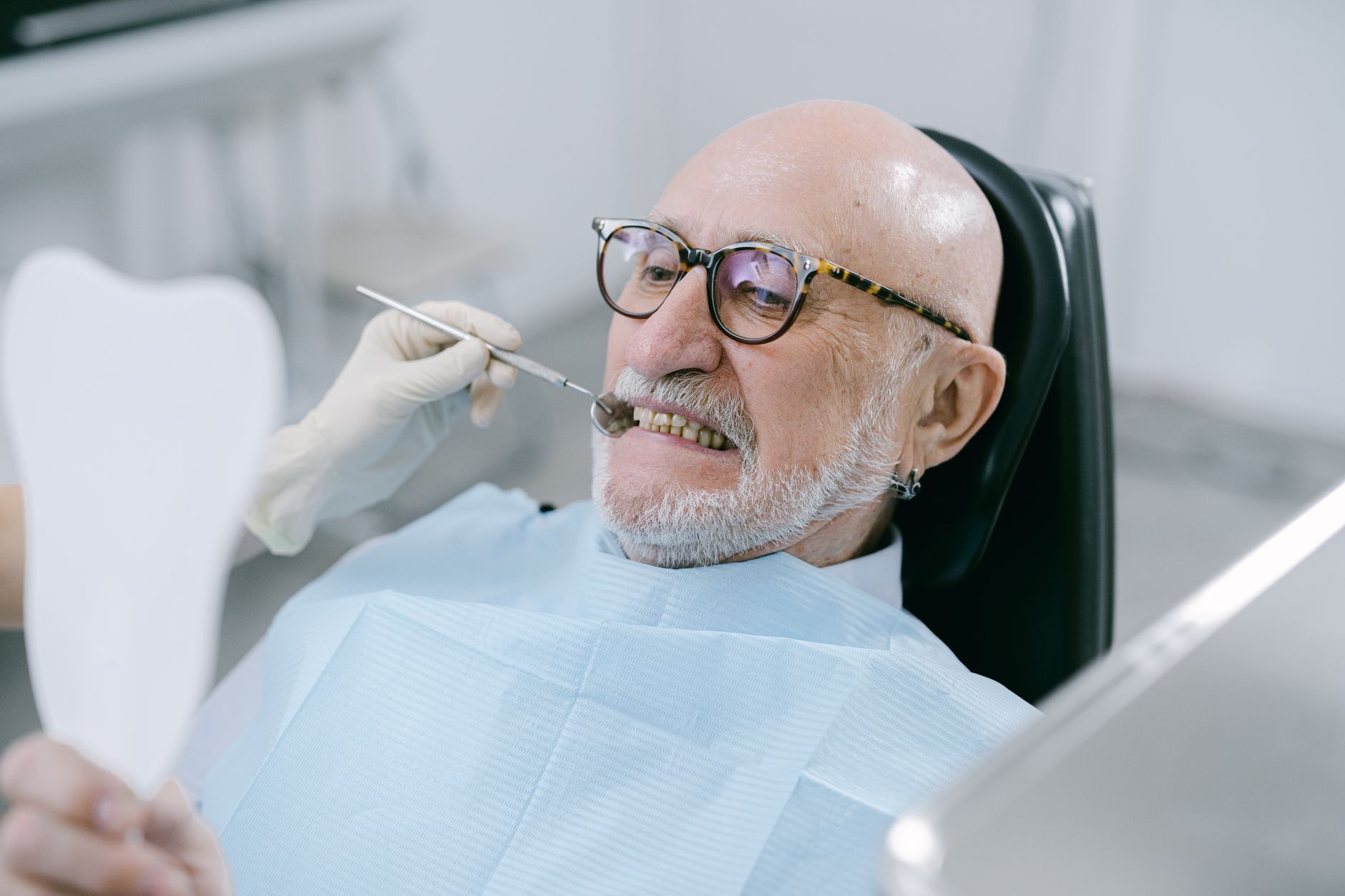 Patient senior souriant en fauteuil dentaire