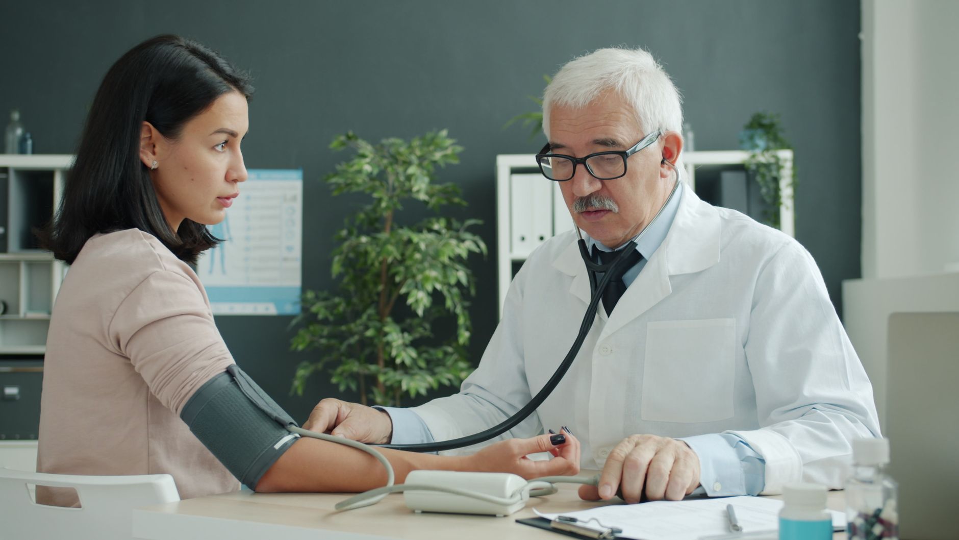 Médecin qui prend la tension d'une patiente