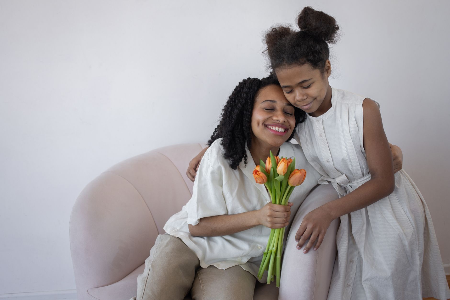 Une mère et sa fille se serrent dans les bras avec des tulipes
