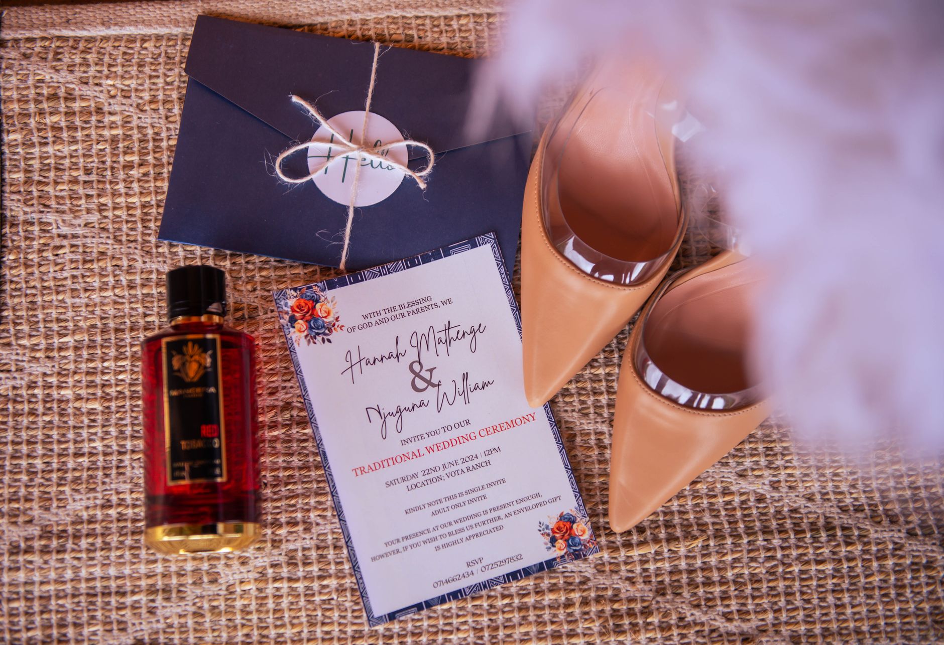 Faire-part, enveloppe et flacon de parfum sur table