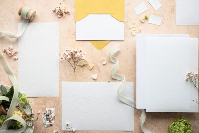 Faire-part de mariage posé avec des fleurs et un ruban