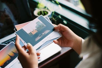 Femme tenant des cartes postales près d'une fenêtre
