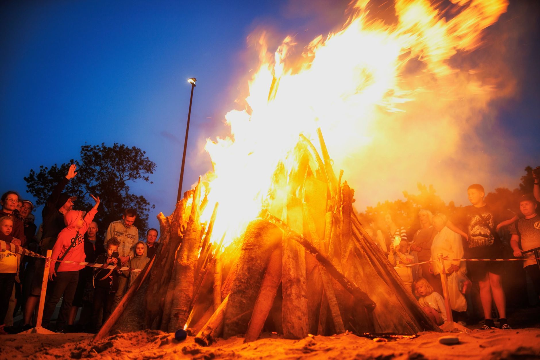 Groupe réuni autour d'un grand feu pour une fête