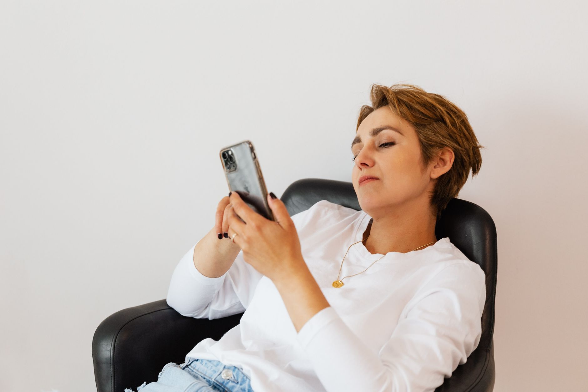 Femme assise qui envoie un message depuis son canapé