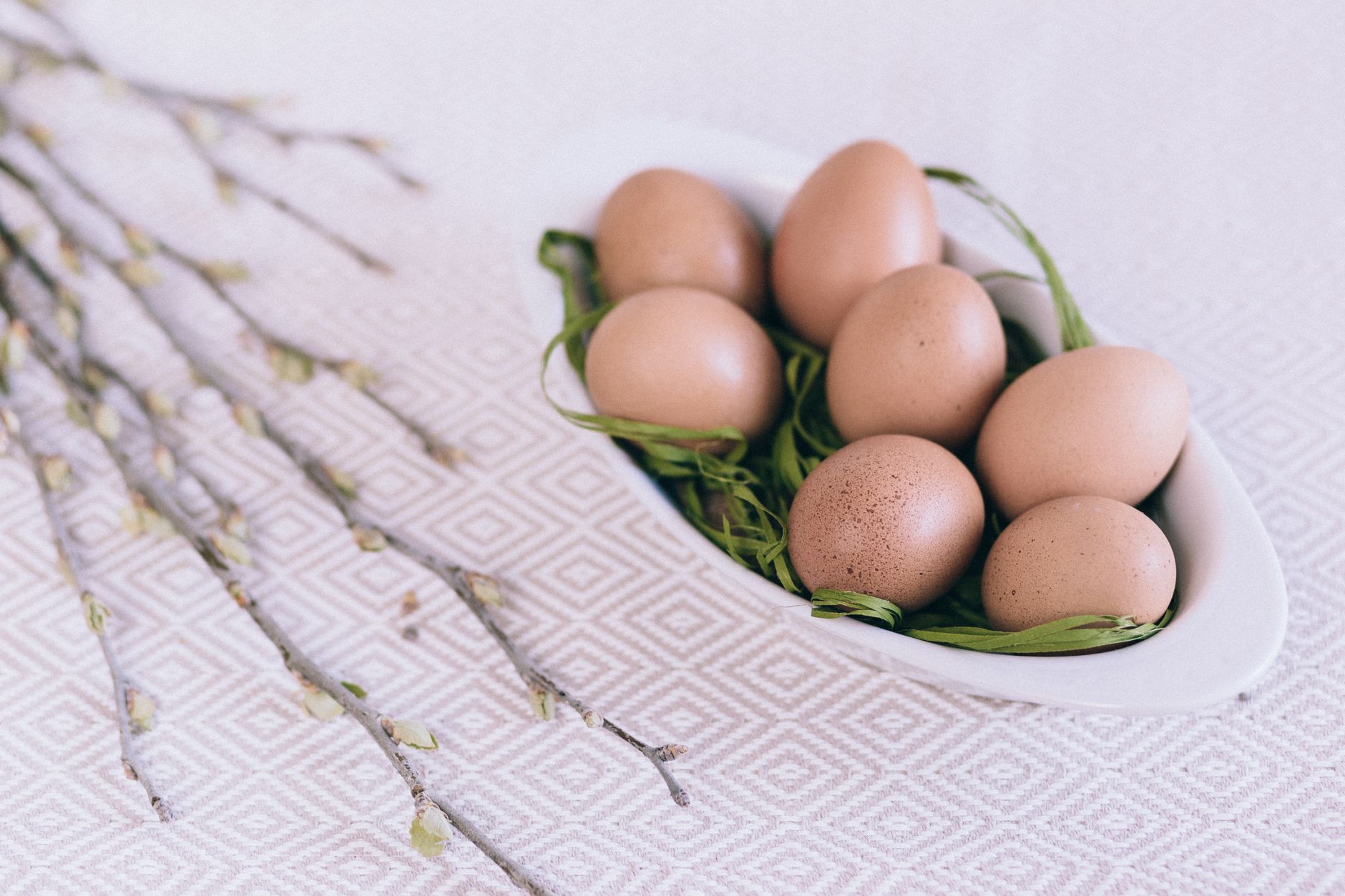 Œufs bruns dans un bol blanc sur une table de printemps