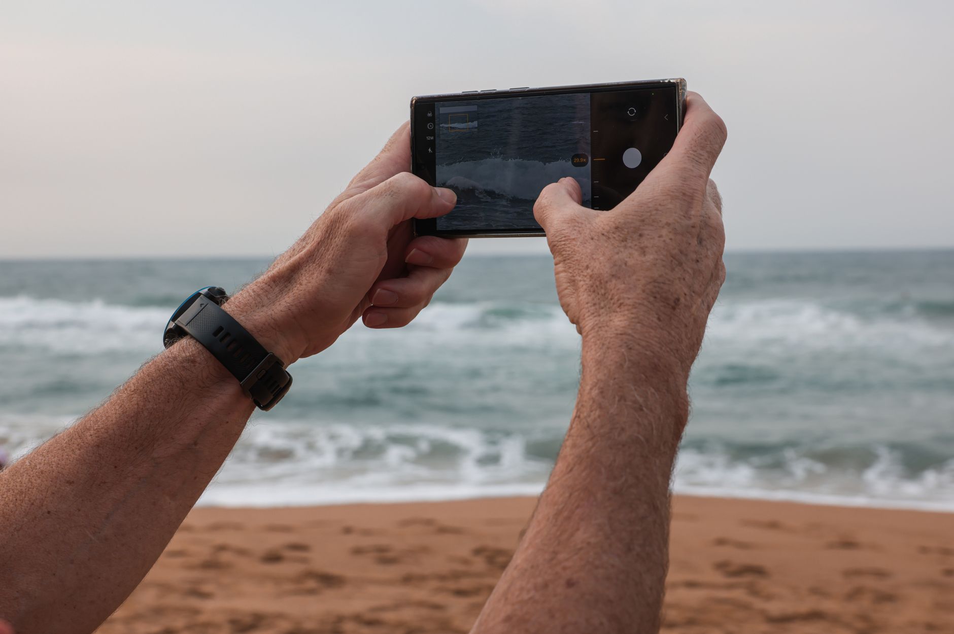 Smartphone qui photographie les vagues sur une plage