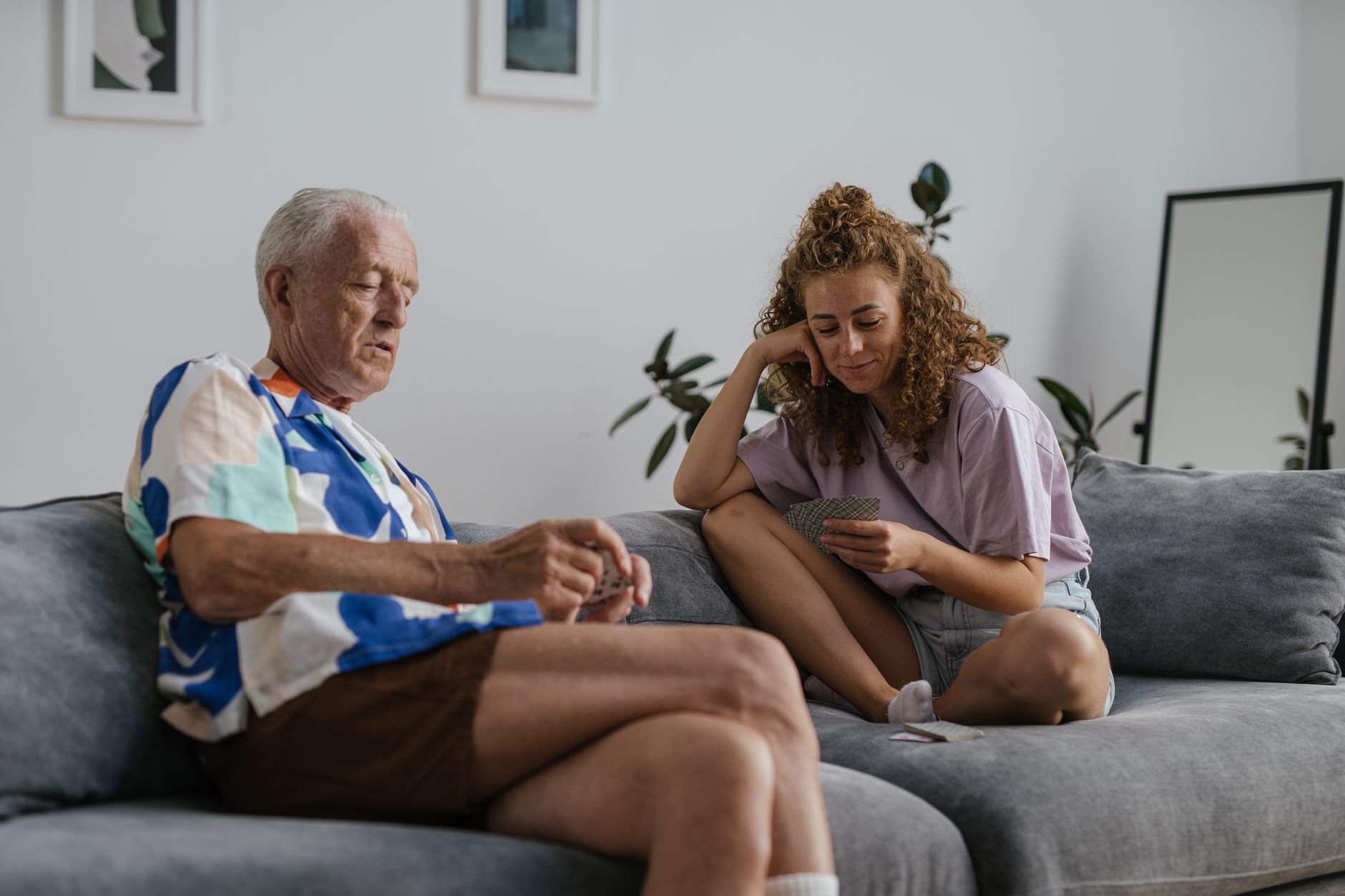 Un senior et une jeune femme discutent sur un canapé